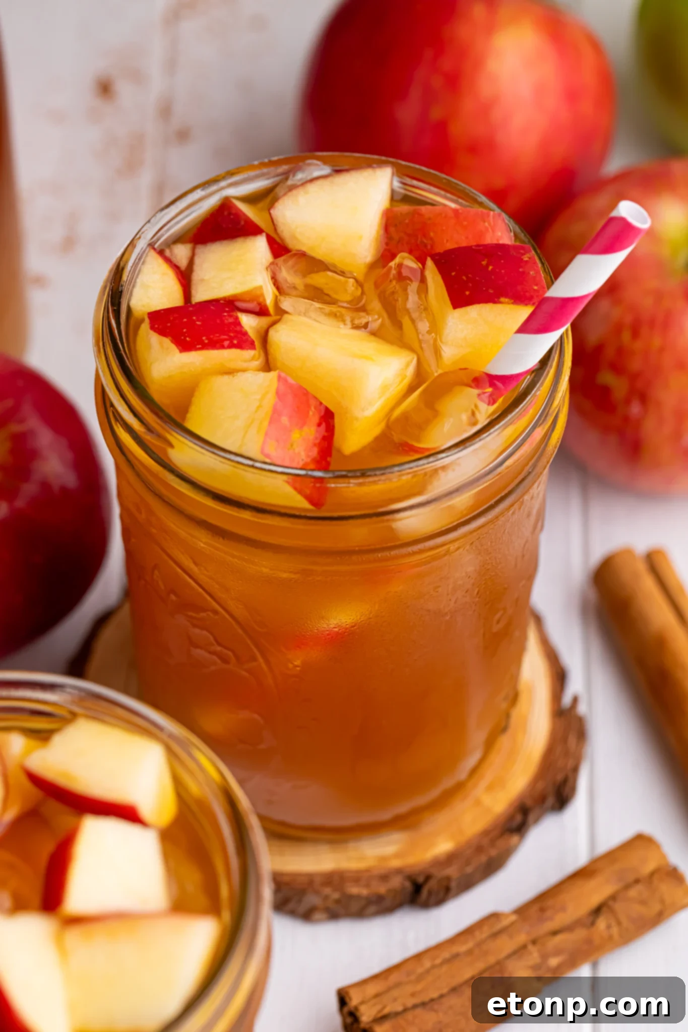Orchard Apple Iced Tea 5 apple cider iced tea in a glass with an overhead look of glass with a straw in it and diced fresh apples with ice cubes