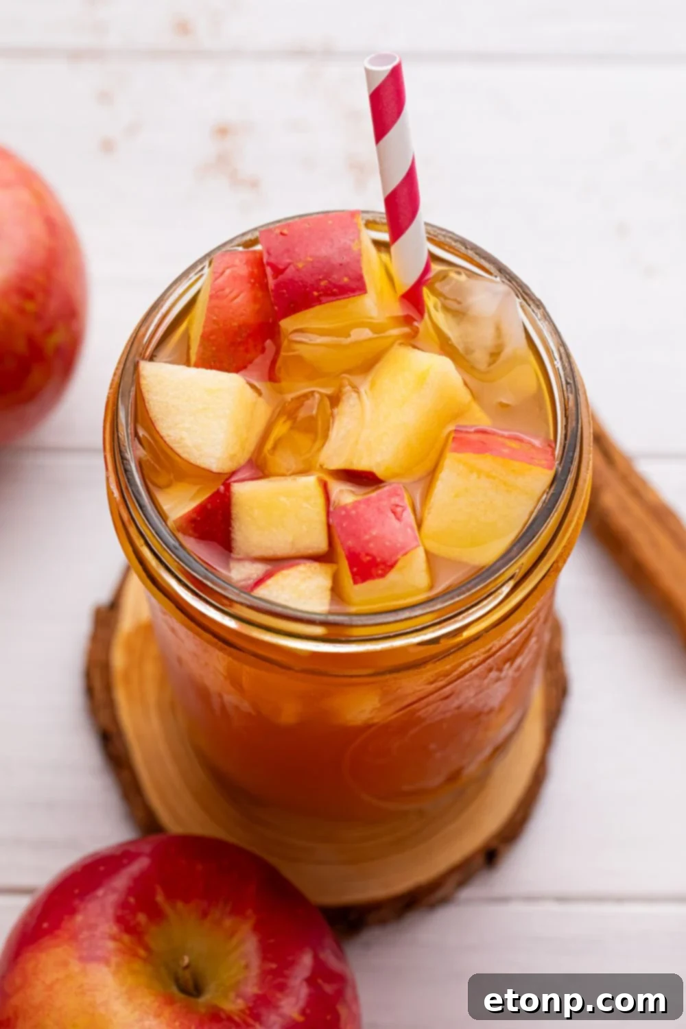 Orchard Apple Iced Tea 9 close up of mason jar with apple cider tea in it and a red and white straw sticking in it