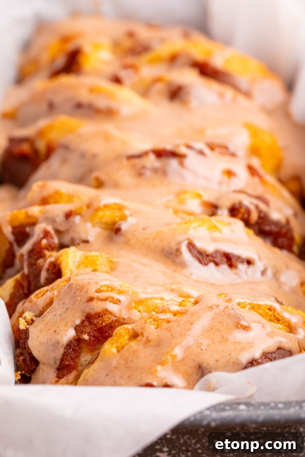 Golden Pumpkin Blossom Bread 17 Pumpkin Pie Pull Apart Bread in a pan with a close up of the maple glaze drizzled on top