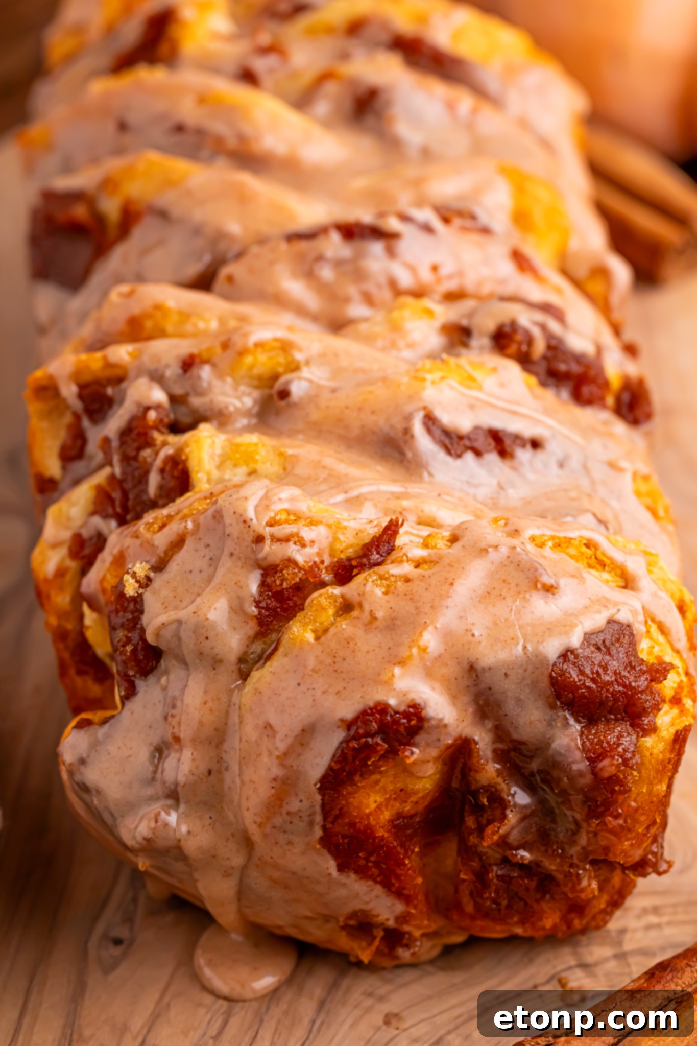 Golden Pumpkin Blossom Bread 18 Pumpkin Pie Pull Apart Bread in a pan with a close up of the maple glaze drizzled on top
