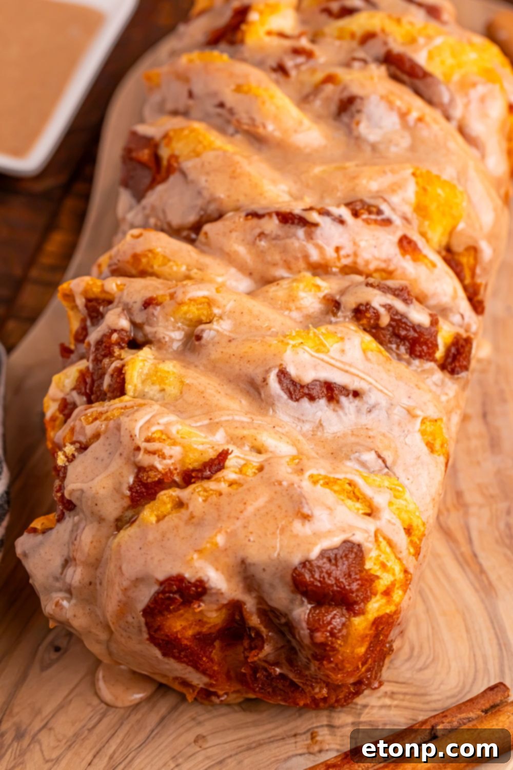 Golden Pumpkin Blossom Bread 19 Pumpkin Pie Pull Apart Bread on a cutting board with glaze on side