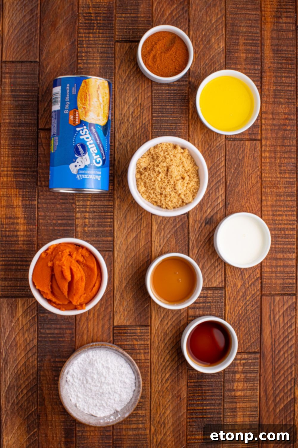 Golden Pumpkin Blossom Bread 5 Pumpkin Pie Pull Apart Bread ingredients on table: can of biscuits, butter, brown sugar, pumpkin puree, spice, powdered sugar, and more in single serve containers.