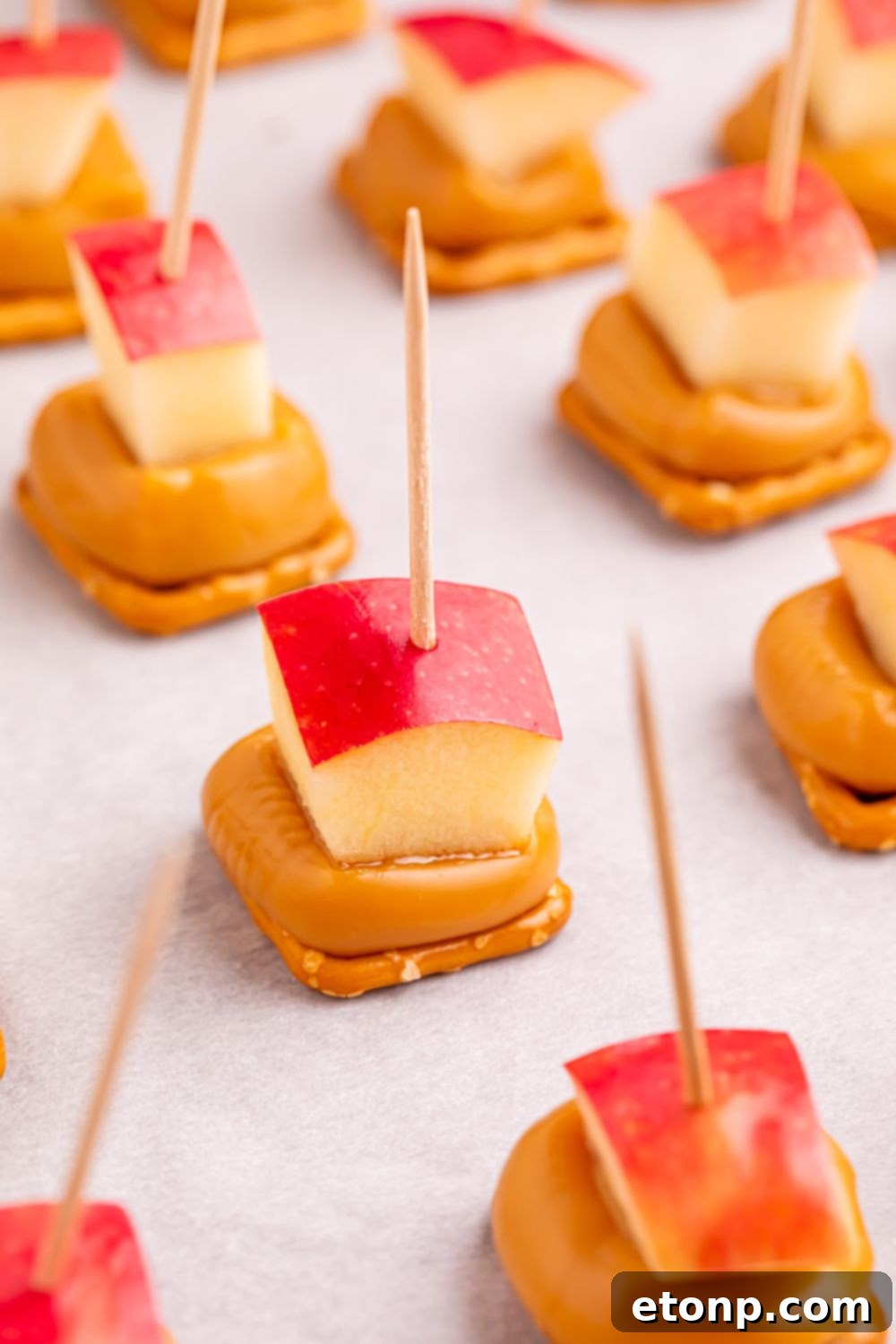 Sweet and Salty Caramel Apple Pretzel Bites 13 caramel apple bites on toothpicks sitting on a cookie tray