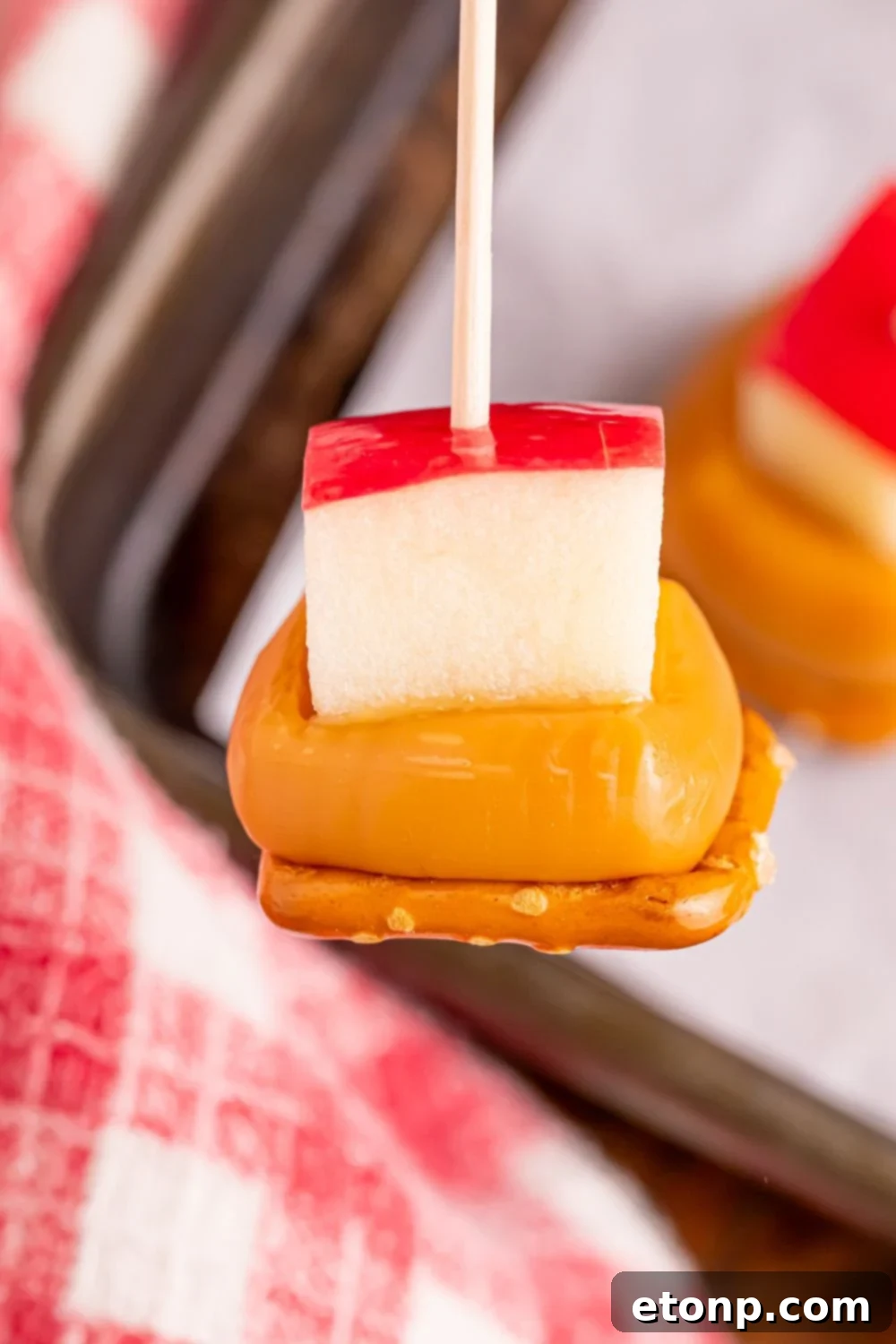 Sweet and Salty Caramel Apple Pretzel Bites 14 close up of a Caramel Apple Pretzel Bite on a stick