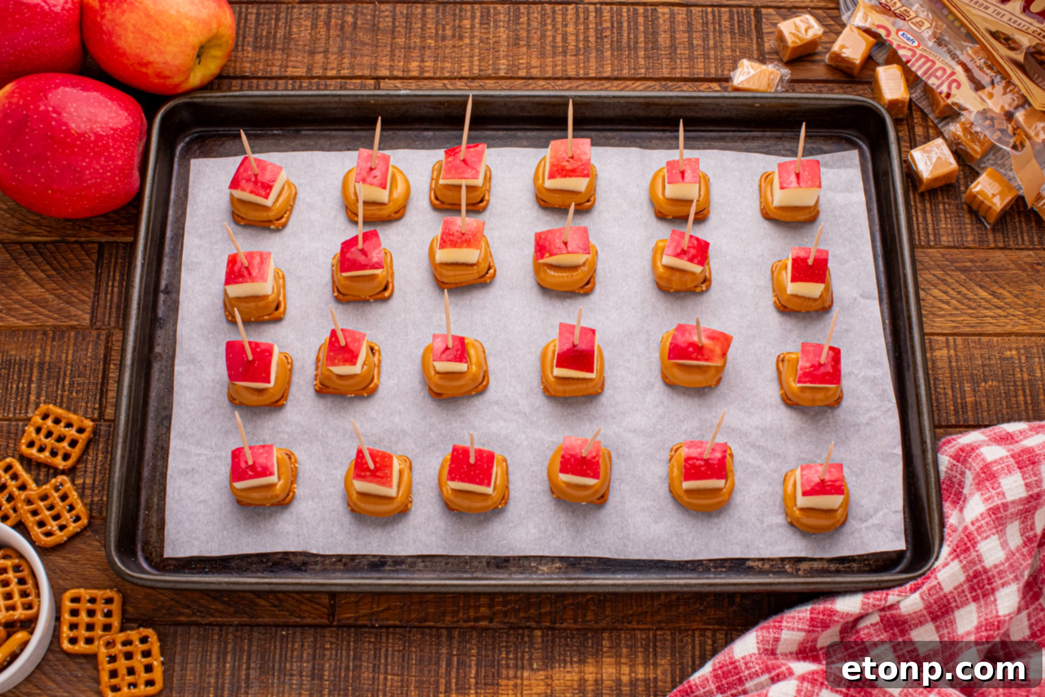 Sweet and Salty Caramel Apple Pretzel Bites 3 Caramel Apple Pretzel Bites on a cookie sheet with toothpick in each