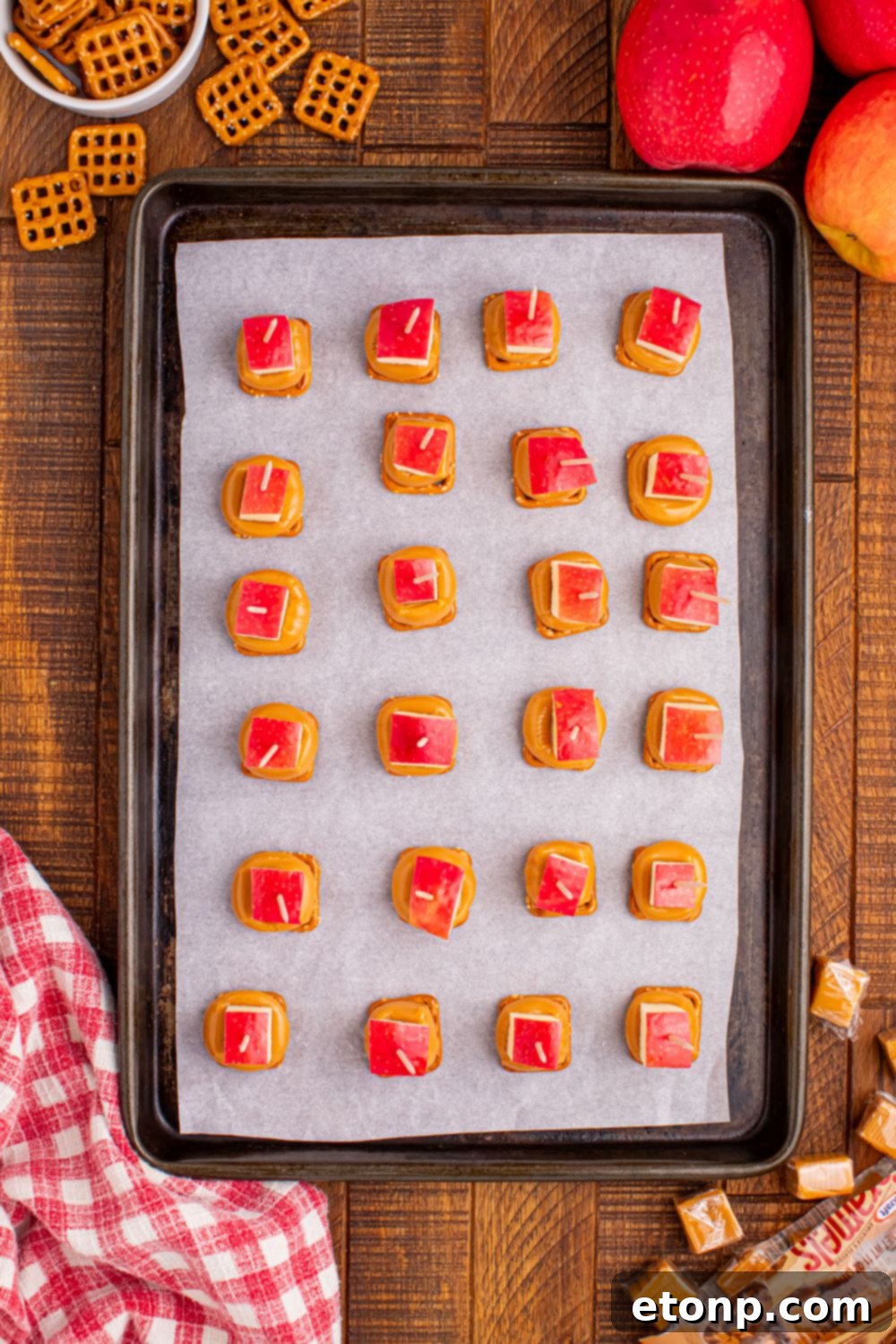 Sweet and Salty Caramel Apple Pretzel Bites 9 caramel apple bites on a baking sheet that are assembled and topped with pretzels