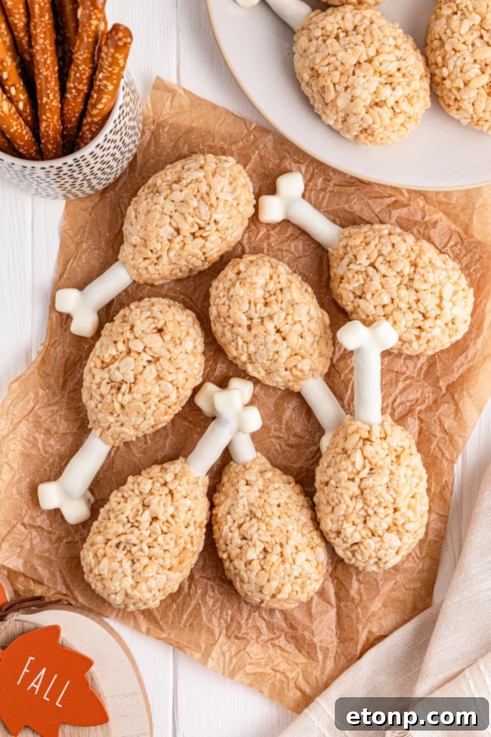 table with Rice Krispie Treat Turkey Legs spread around with pretzel rods and other ingredients around it in bowls 