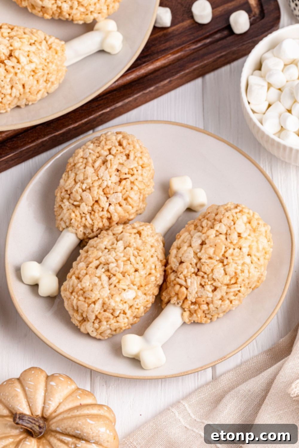 overhead of rice krispies turkey legs on plate with bowl of marshmallows on the side 
