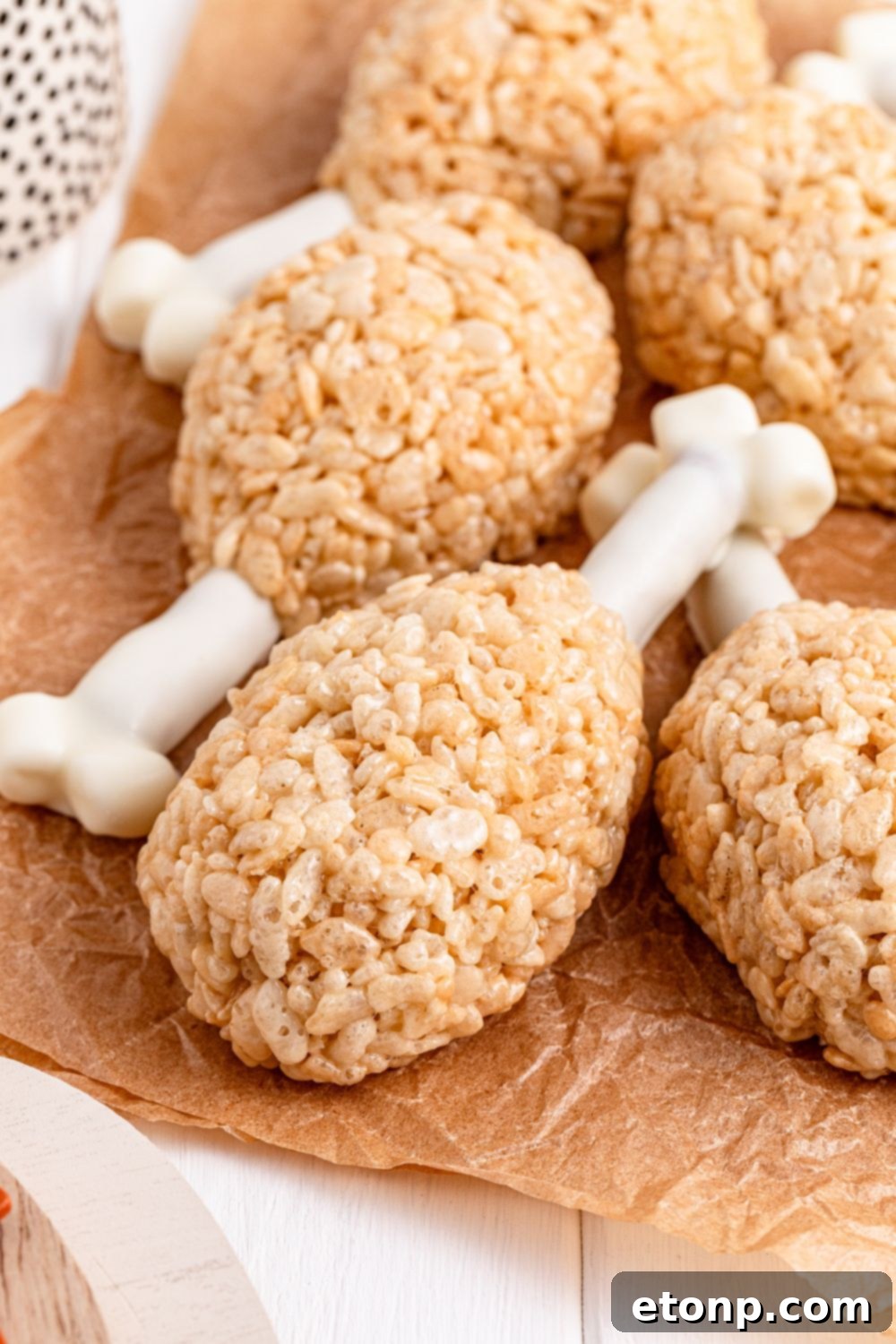 Rice Krispie Treat Turkey Legs on wax paper on table with the drumsticks stacked on top of one another 