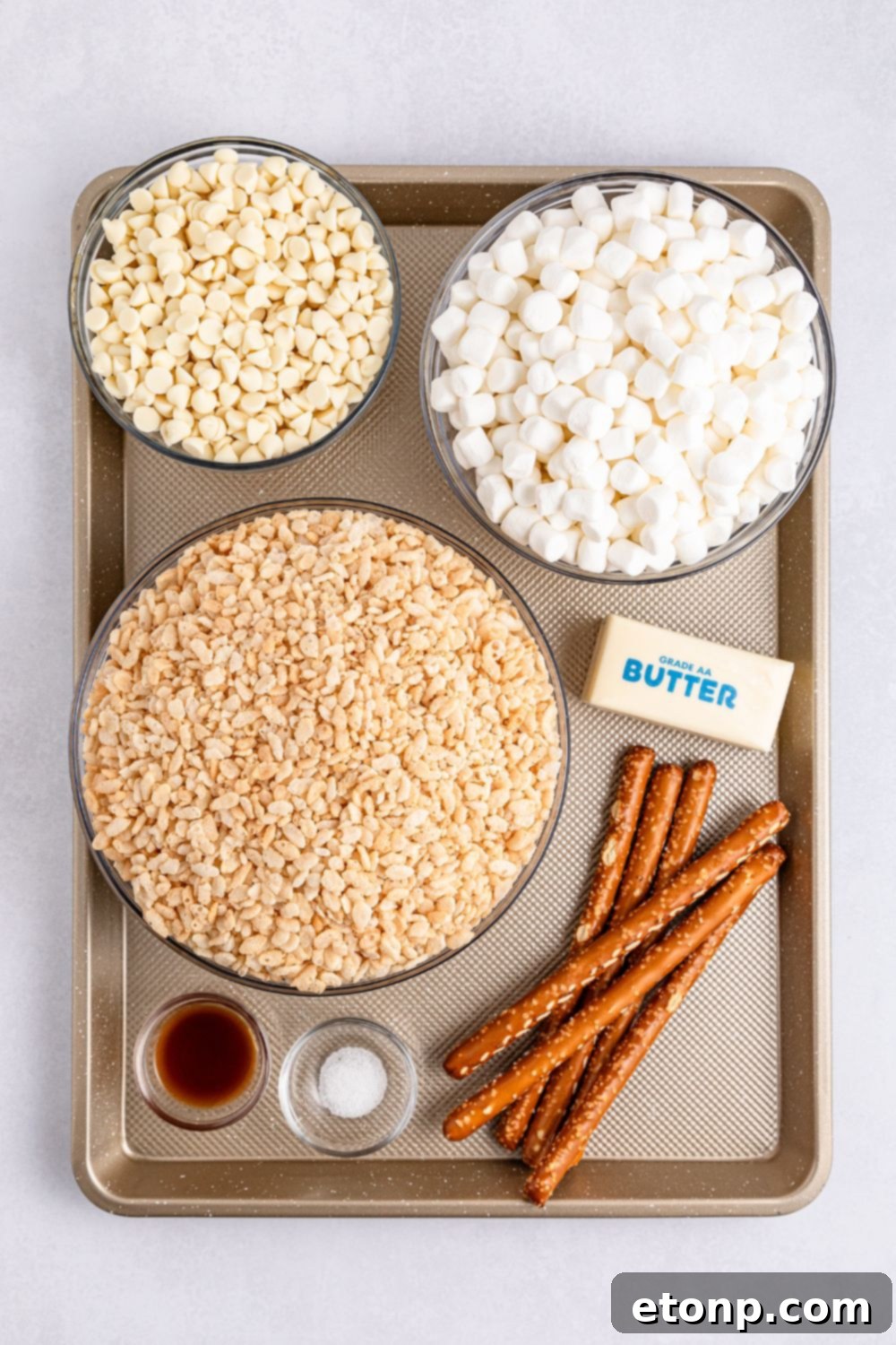 ingredients to make Rice Krispie Treat Turkey Legs on tray on table: stick of butter, pretzel rods, rice krispies, marshmallows, white chocolate, etc