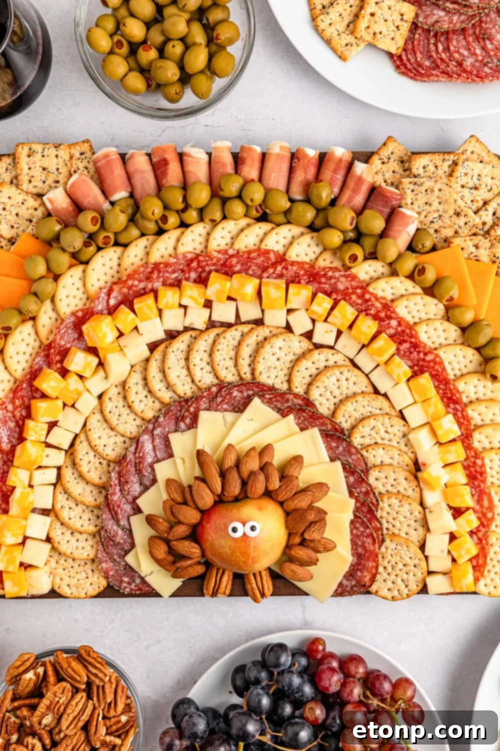 Turkish Mezze Spread 11 Turkey Snack Board on a table, with small decorative bowls of olives, a plate of grapes, and other accompaniments surrounding the main snack board.