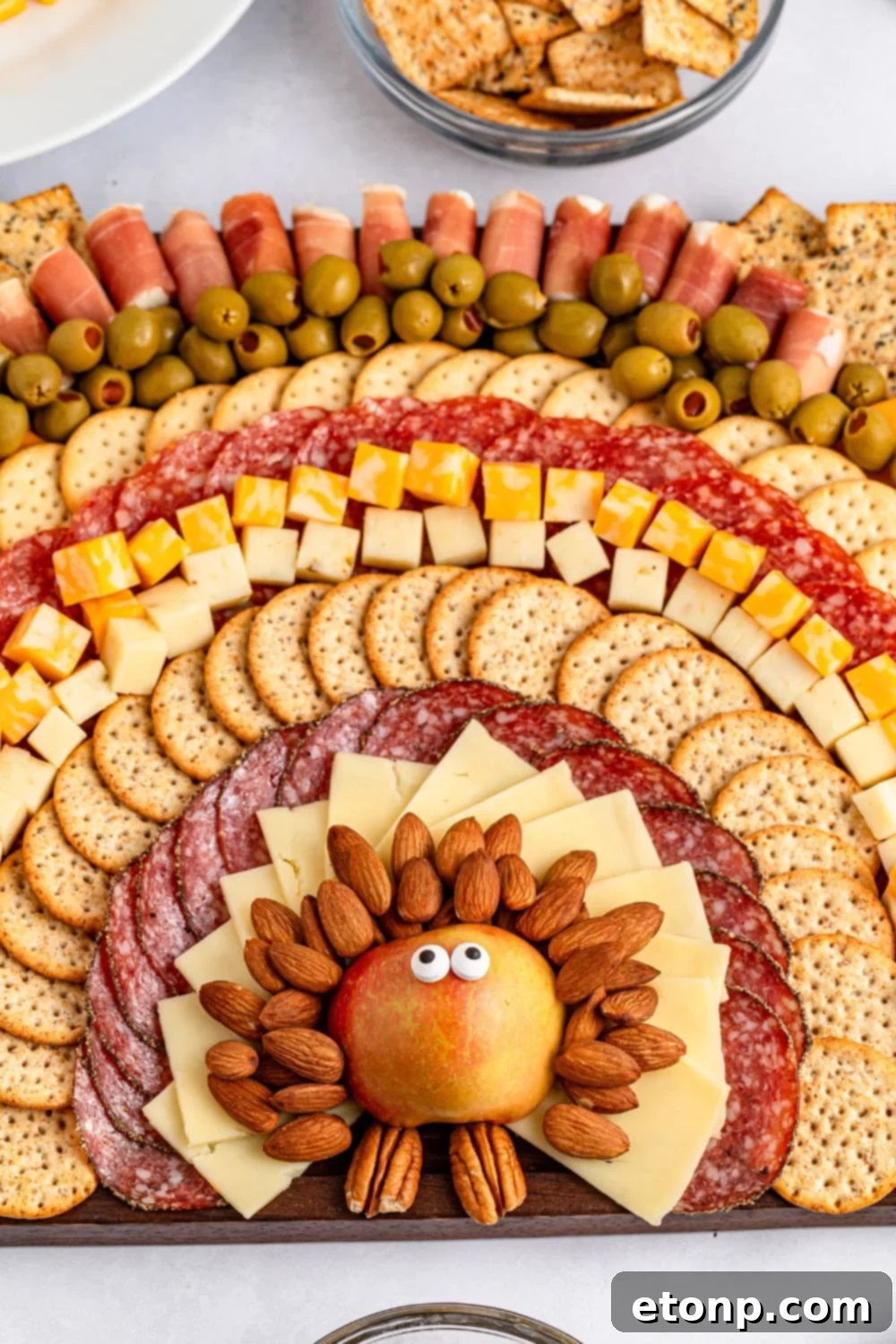 Turkish Mezze Spread 15 Thanksgiving Turkey Snack Board featuring an array of meats, cheeses, and more, arranged to form a turkey and its feathers on a large platter.