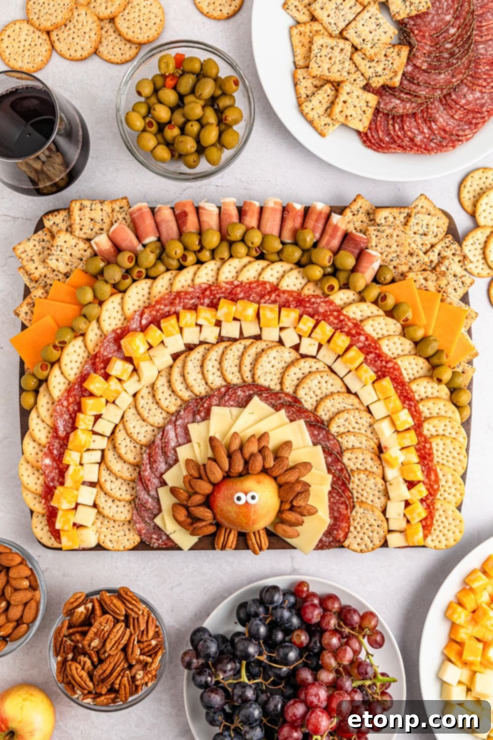 Turkish Mezze Spread 16 Thanksgiving Turkey Cheese Board presented on a table, with accompanying bowls of grapes and nuts, and platters of additional meats and cheeses surrounding the main tray.