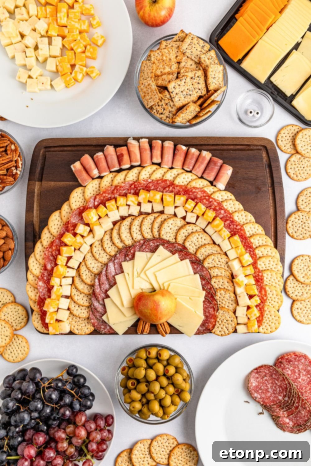 Turkish Mezze Spread 8 Cheese and crackers being added to the board, continuing the formation of the turkey's 'feathers' with varied ingredients.