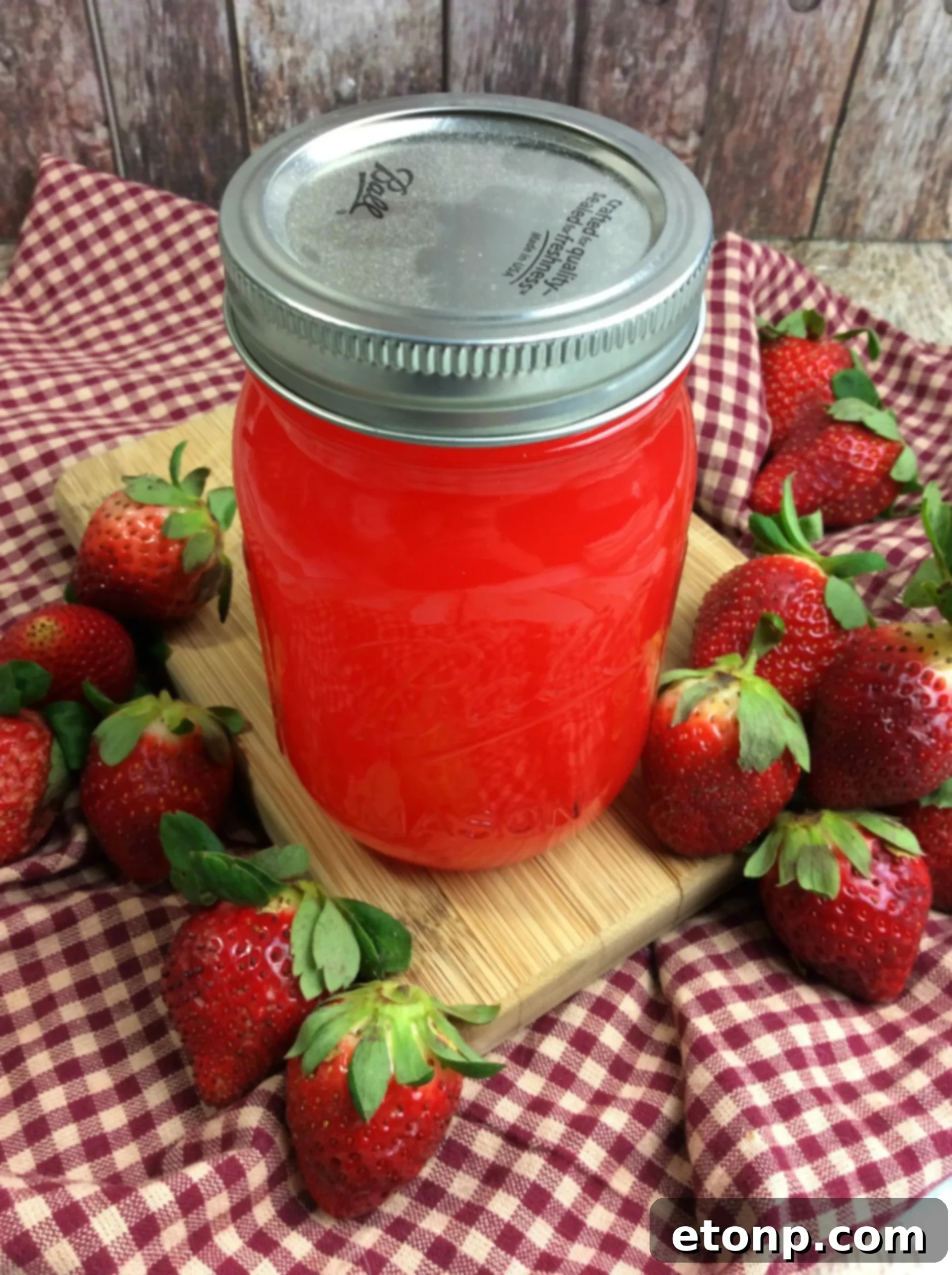 Mason jars being filled with strawberry moonshine