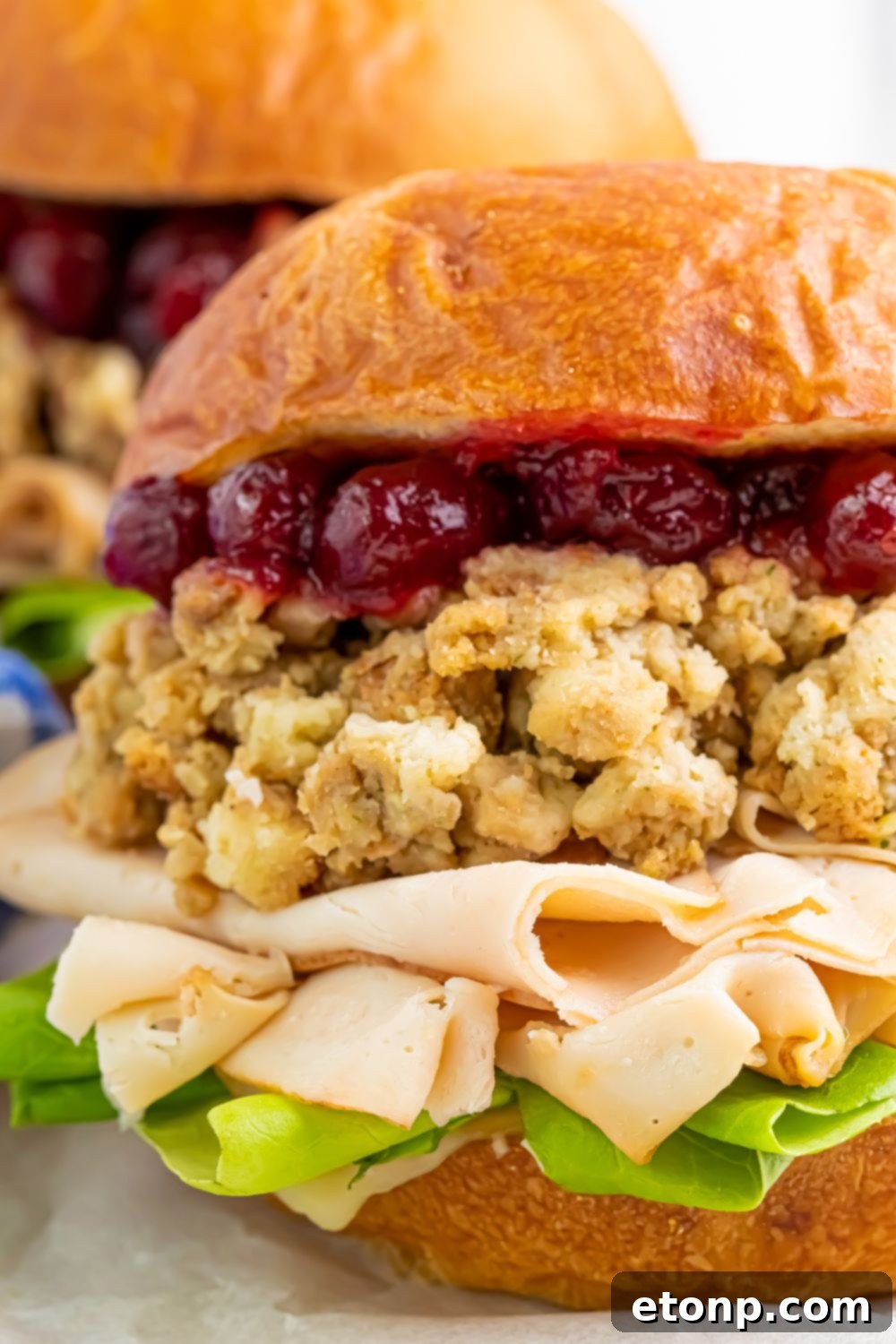 Leftover Turkey Sandwiches on table with a close up to see each ingredient in the sandwich 