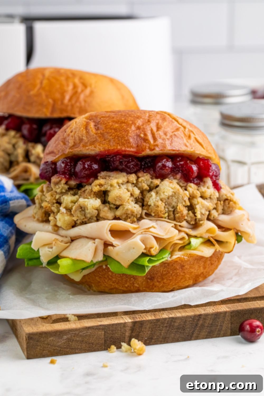 front view of turkey sandwiches stuffed with stuffing and cranberry sauce sitting on table