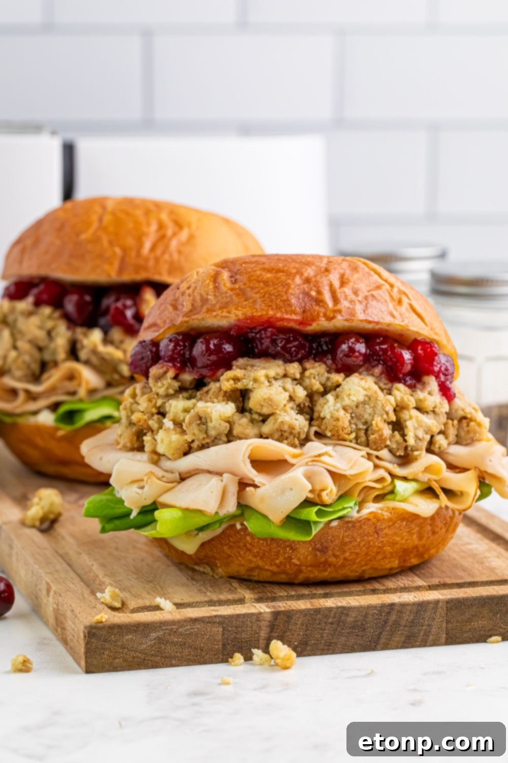 Leftover Turkey Sandwiches sitting on a cutting board on table 