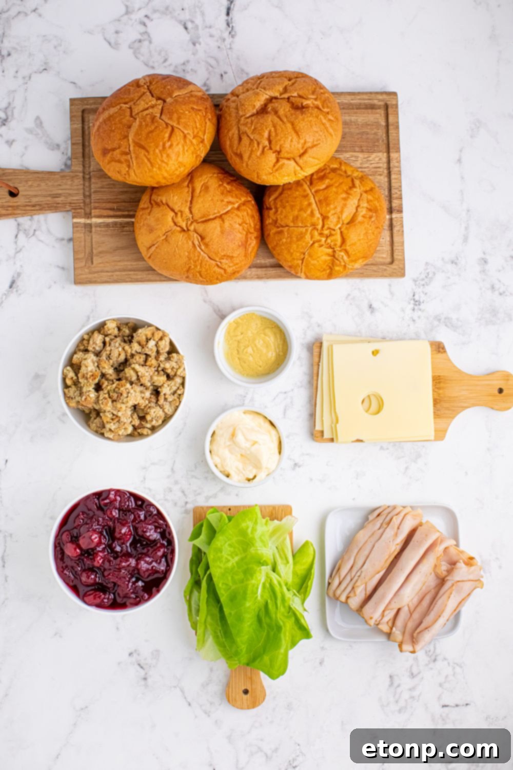 ingredients for leftover Turkey Sandwiches on table. Cranberry, stuffing, turkey, cheese, lettuce, rolls, condiments 