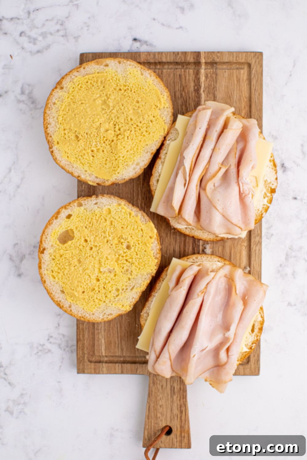 sliced rolls with turkey and cheese lunch meat on the buns 