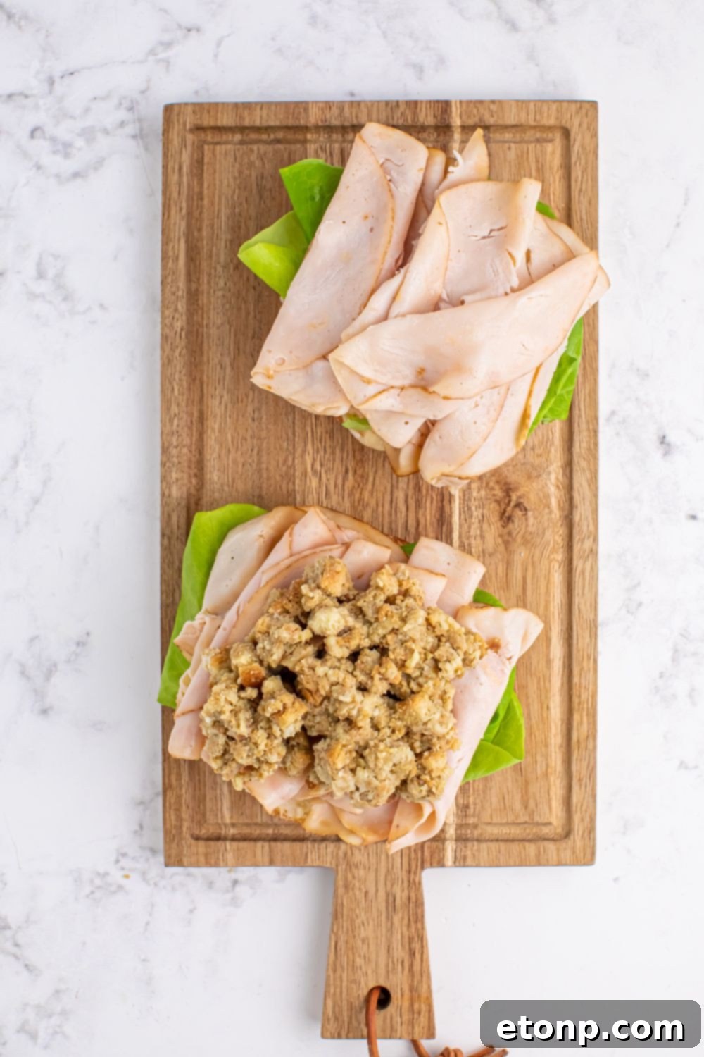 Leftover Turkey Sandwiches being assembled with meat and stuffing on the sliced roll 