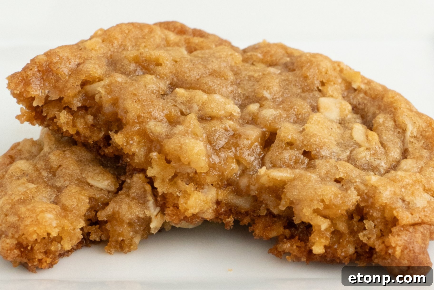Chewy Toffee Oatmeal Cookies 13 A close-up view of an Oatmeal Toffee Cookie broken open, revealing its soft, chewy interior and abundant toffee bits.