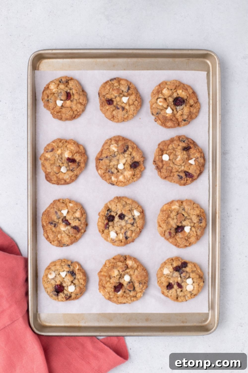 White Chocolate Cranberry Oatmeal Cookies on a baking sheet sitting on table 