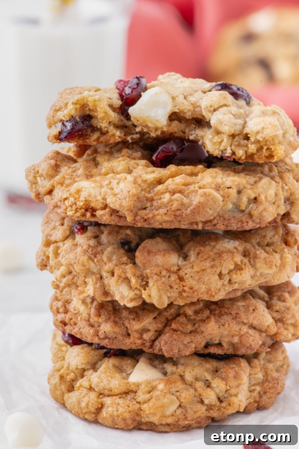 White Chocolate Cranberry Oatmeal Cookies stacked on plate with a few bites taken out of the top one 