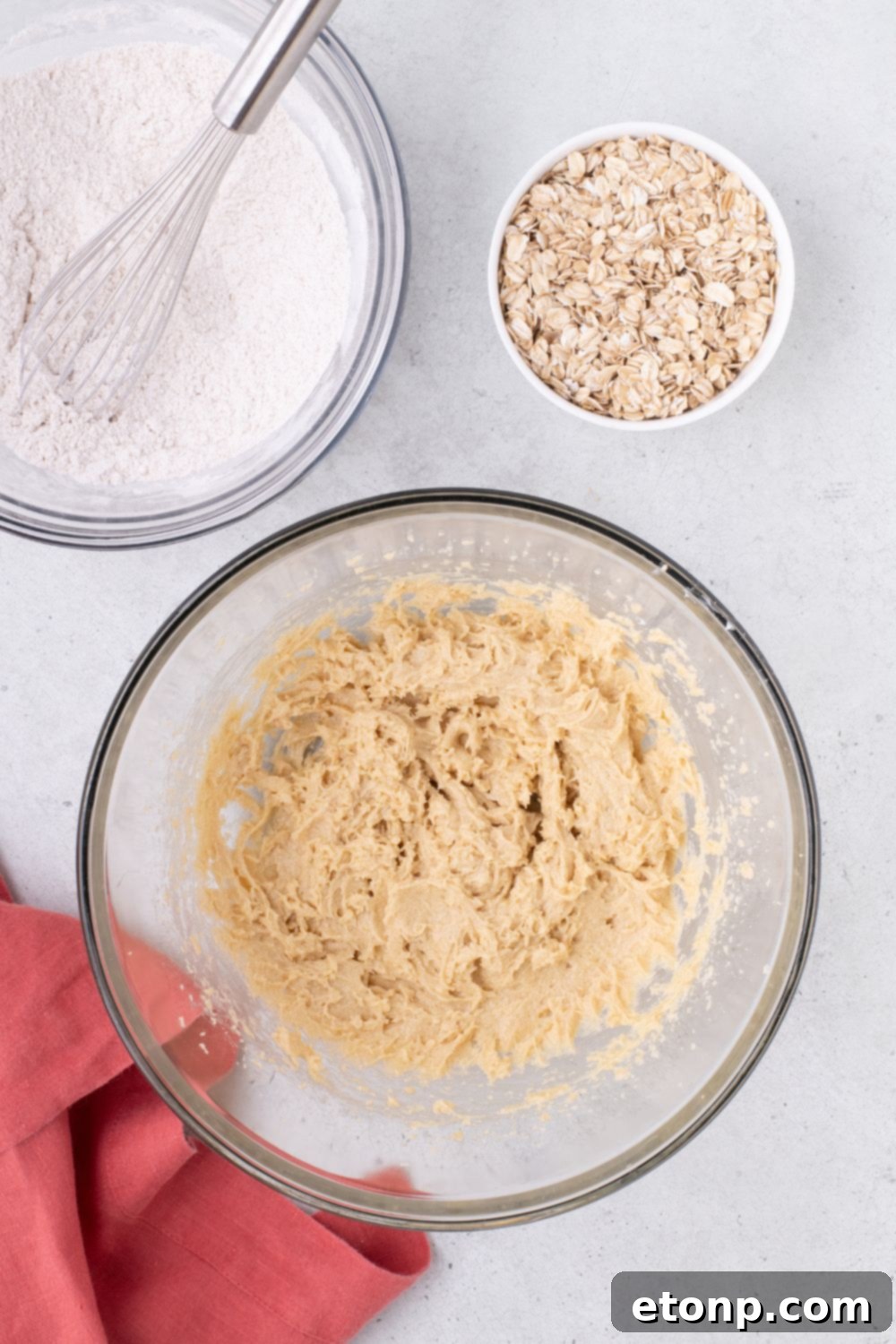 cookie batter on table with oats and flour mixture in separate bowls on table 