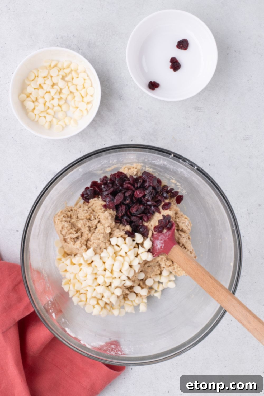 dried cranberries and white chocolate chips and White Chocolate Cranberry Oatmeal Cookie dough in a bowl on table 