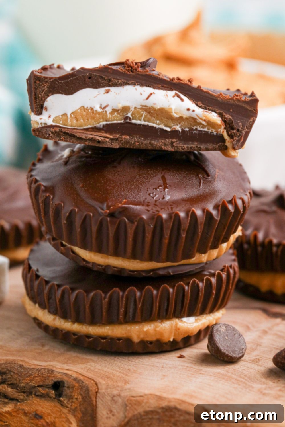 Peanut Butter Marshmallow Cups stacked on top of one another and a close up of top one cut in half to see layers of filling