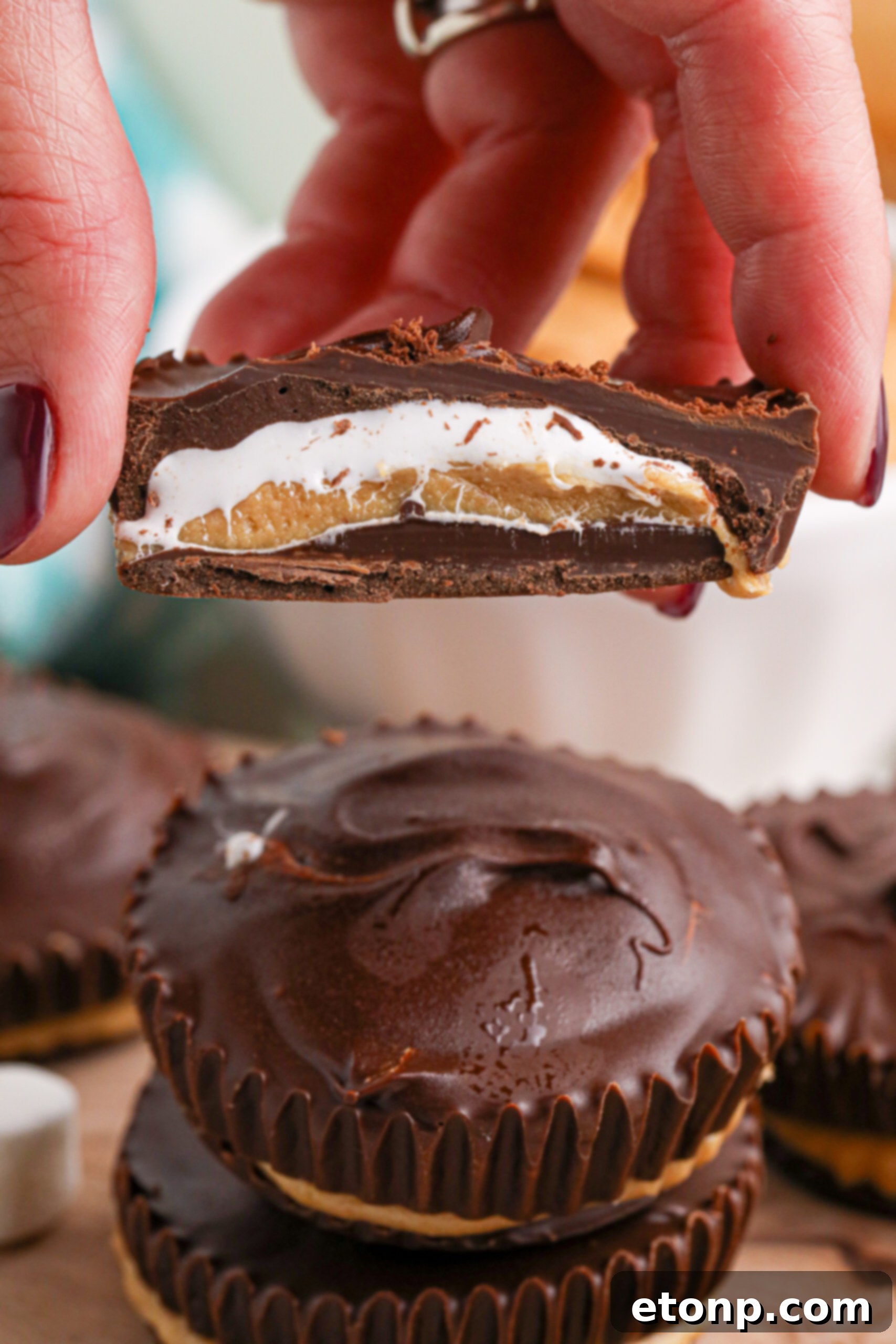 Hand holding a cut open marshmallow peanut butter cup showing the inside 