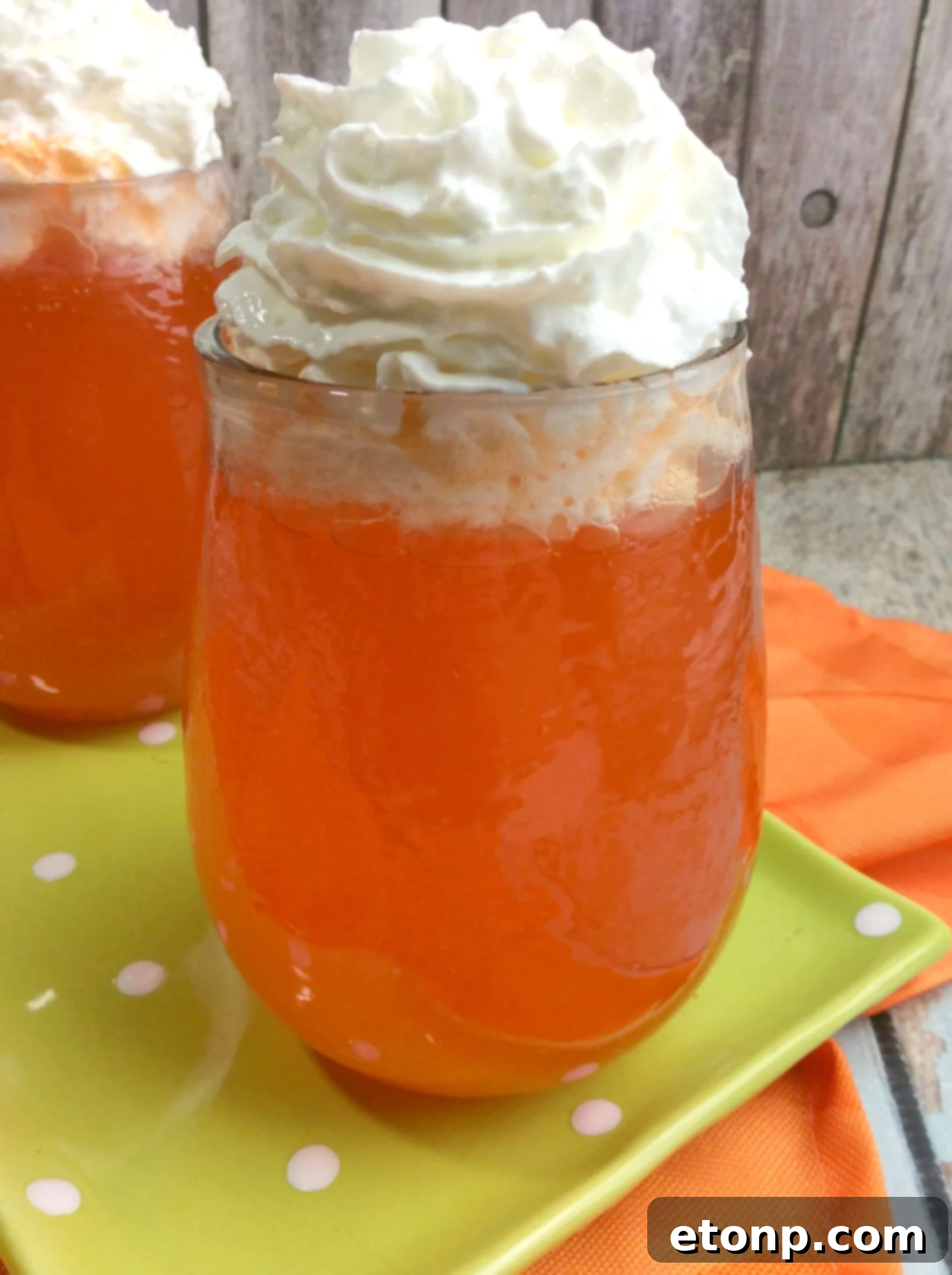 Refreshing Orange Creamsicle Cocktail garnished with a fresh orange slice and whipped cream in a tall glass, evoking summer memories.
