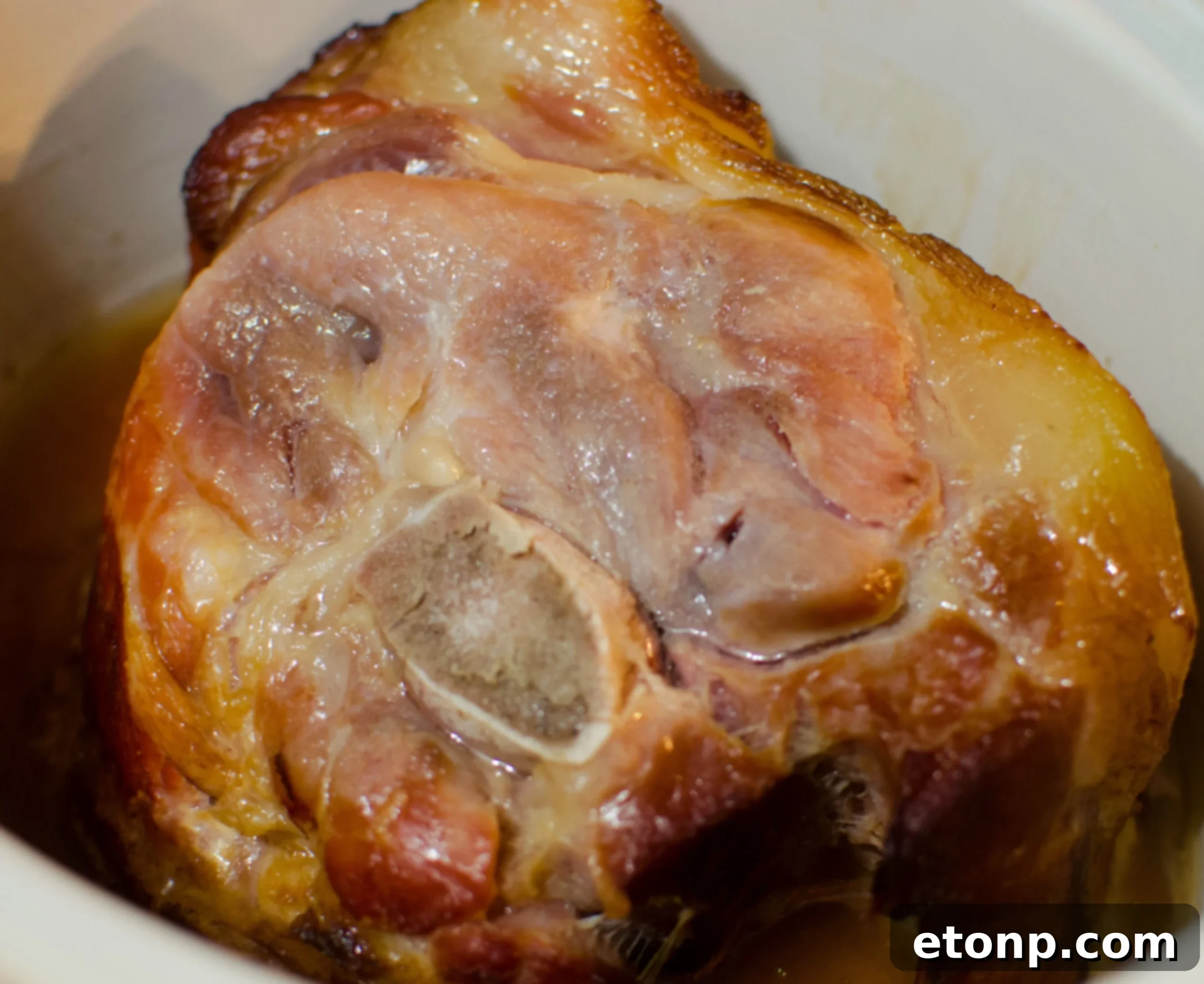 A whole Coca-Cola glazed ham, glistening with caramelized brown sugar
