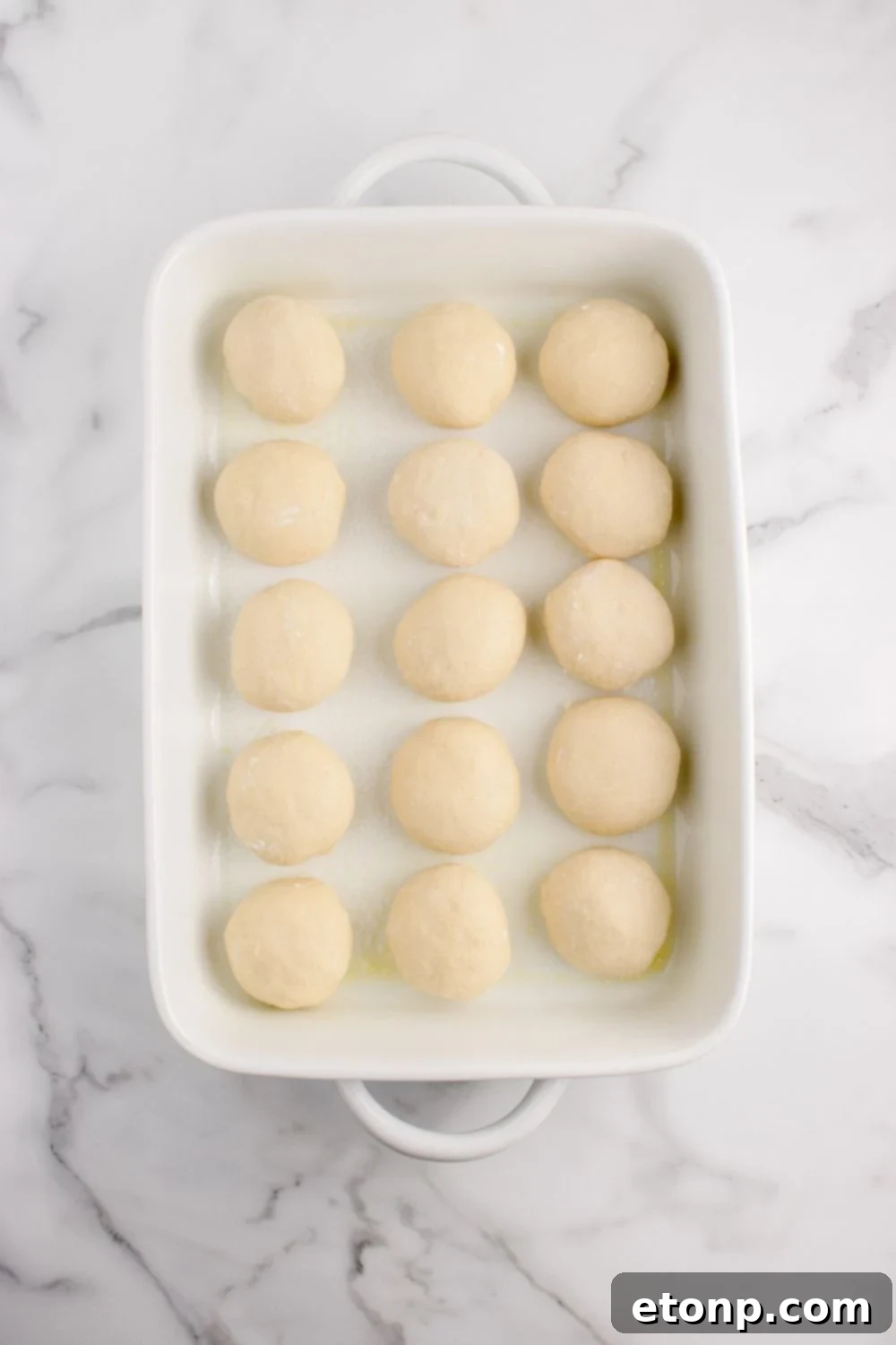 Hawaiian rolls dough in a baking dish on counter in a baking dish 