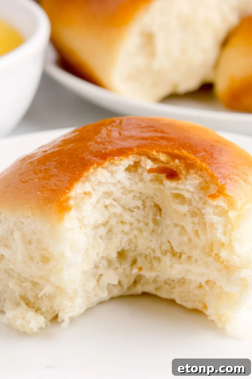 Hawaiian Dinner Roll on plate with a bite taken out of it 