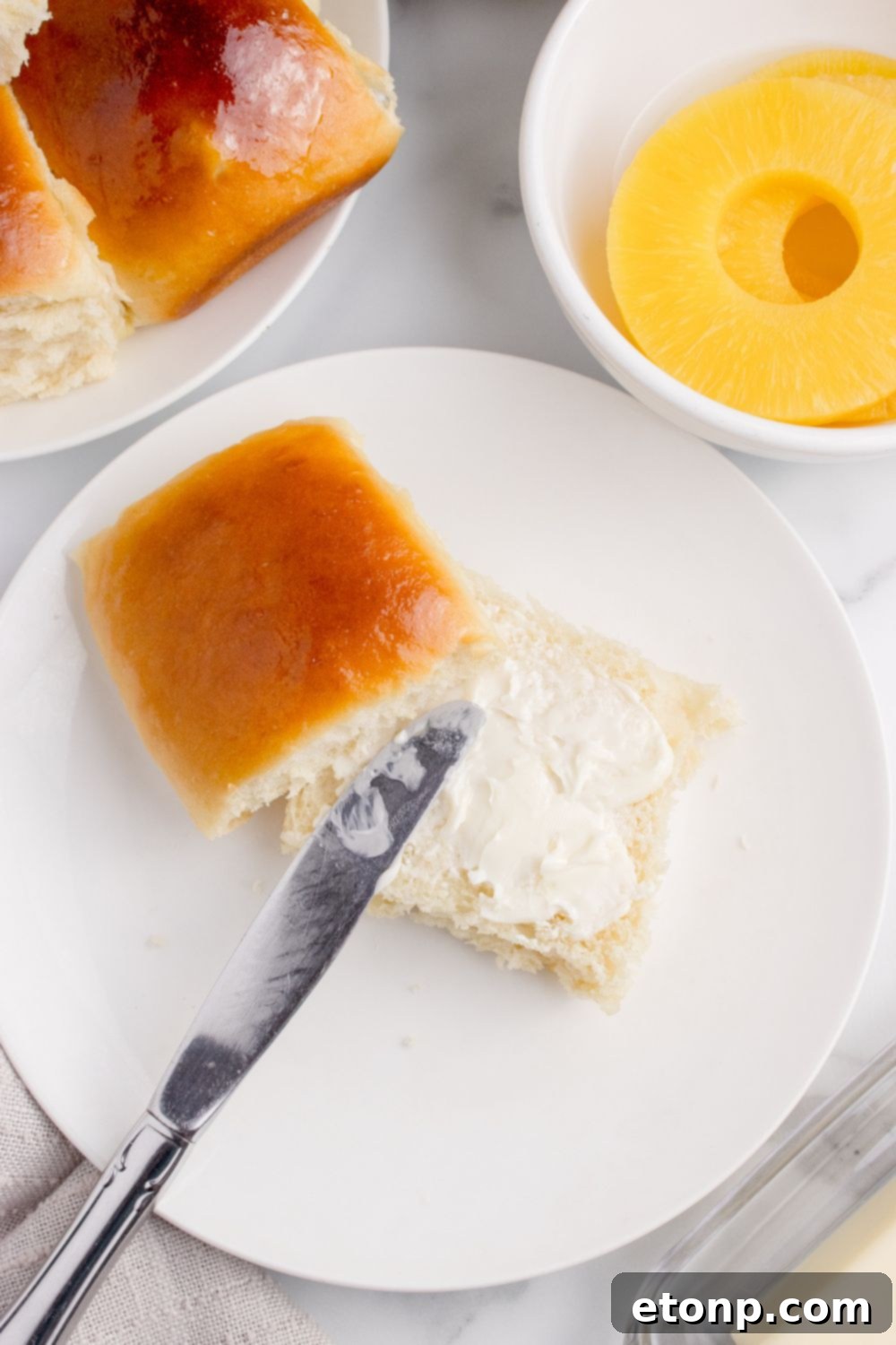 dinner roll with butter spread on top of it on plate 