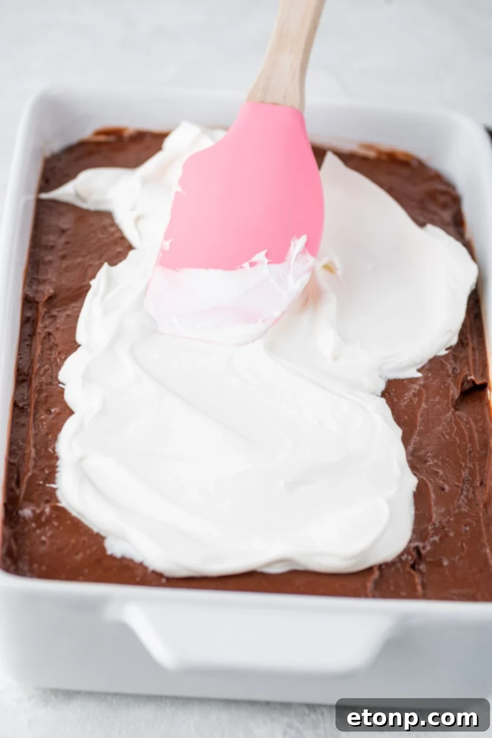 Decadent Chocolate Oreo Dream 9 whipped cream being spread on top of pudding layer for the Chocolate Oreo Lush