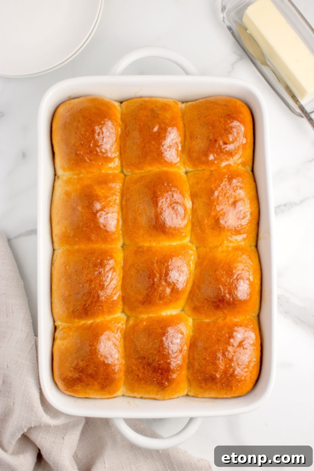 Freshly baked, buttery pull apart rolls in a casserole pan on a table, golden and inviting