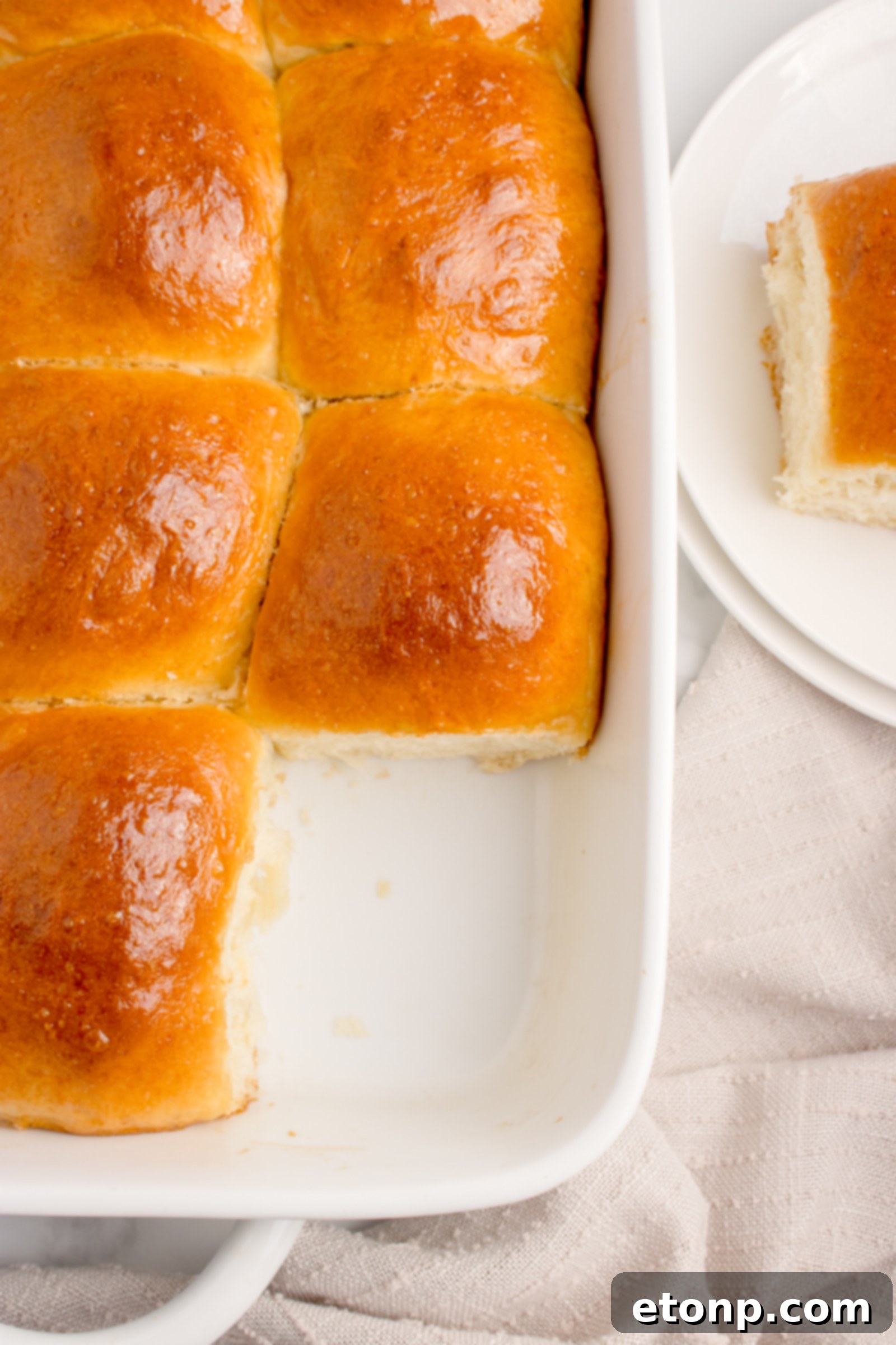 Pull Apart Dinner Rolls in a white baking dish with one roll removed, showing the uniform baking