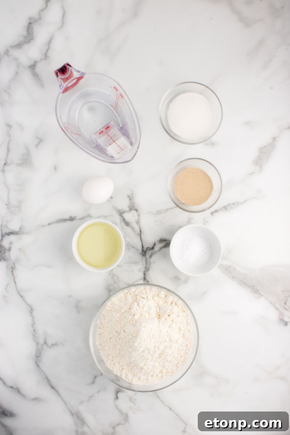 A collection of ingredients for pull apart dinner rolls, neatly arranged in individual serving containers on a kitchen counter