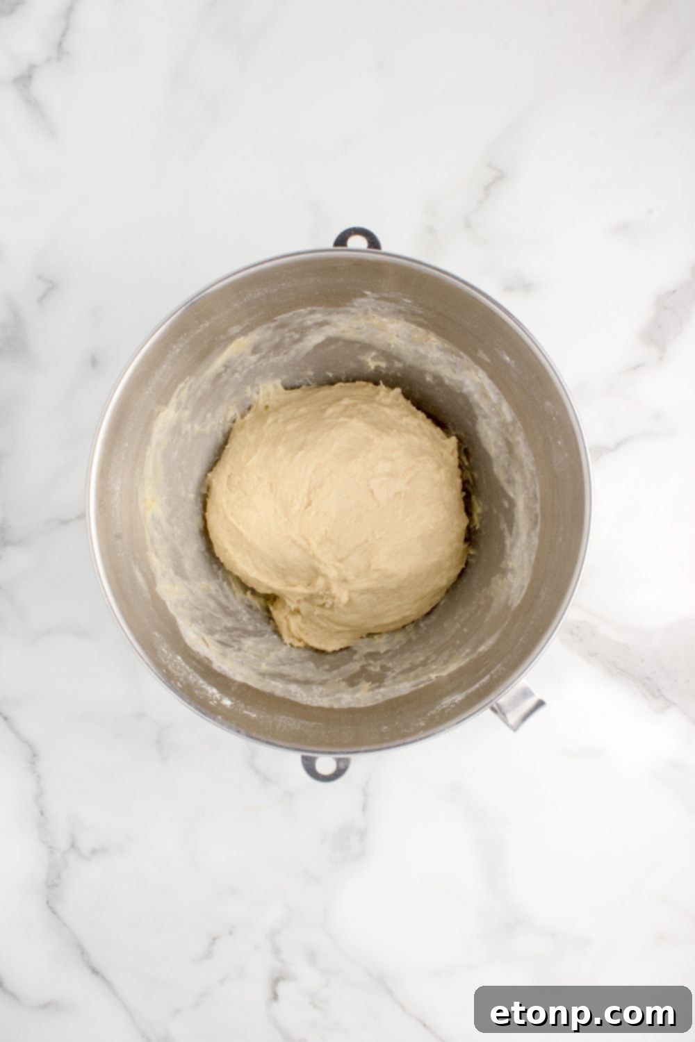 Smooth, well-kneaded pull apart roll dough shaped into a ball in a mixing bowl