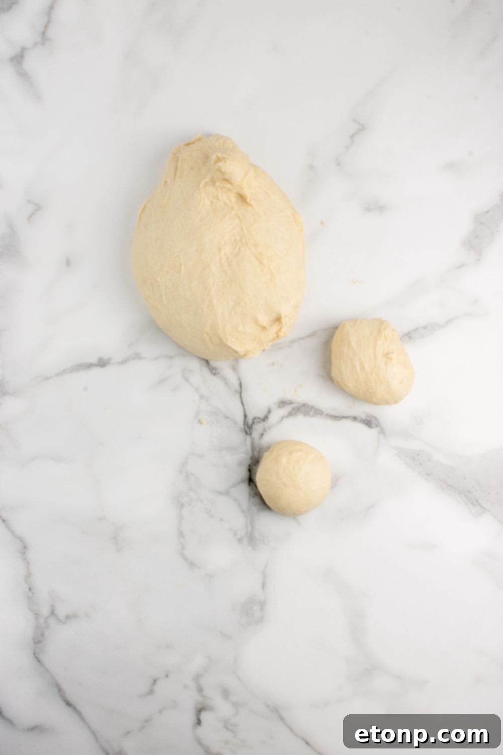 Portioned pull apart roll dough on a counter, rolled into uniform balls ready for baking