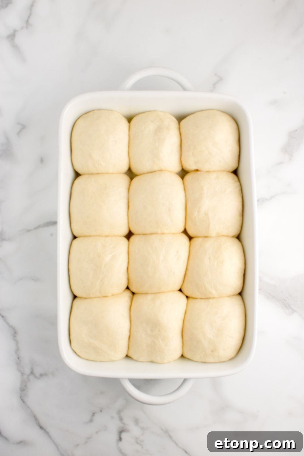 Risen pull apart roll dough arranged in a casserole dish, ready for the oven