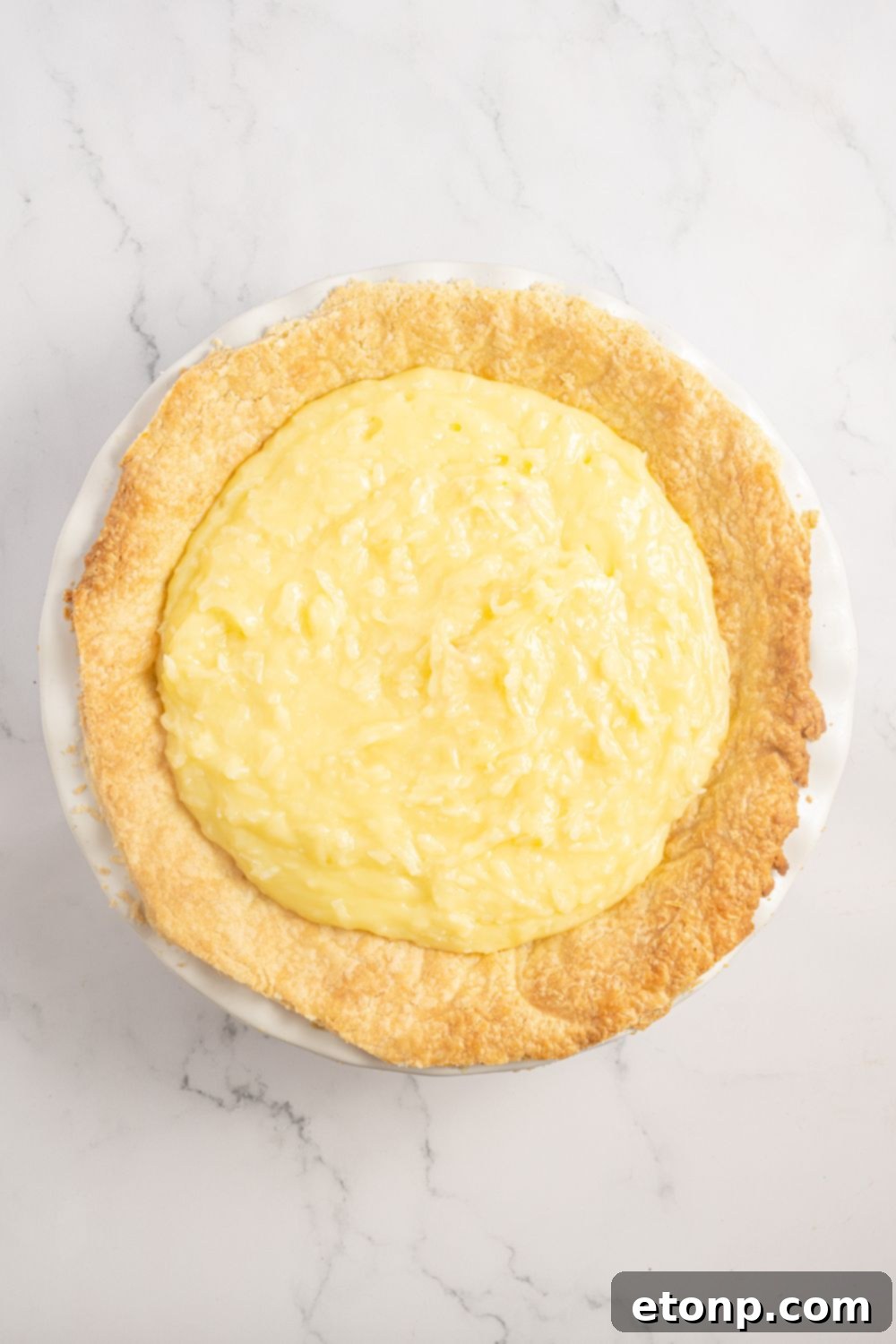 Coconut Meringue Pie filling in a pie crust on table