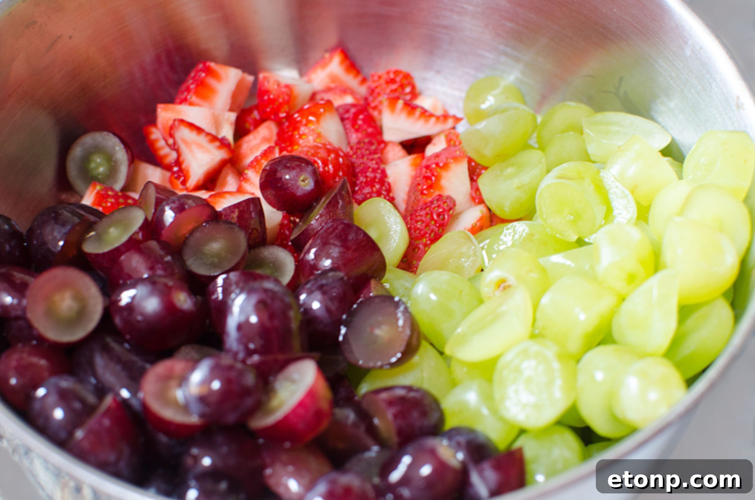 Overhead shot showcasing the incredible array of fresh fruit in the salad, glistening with glaze