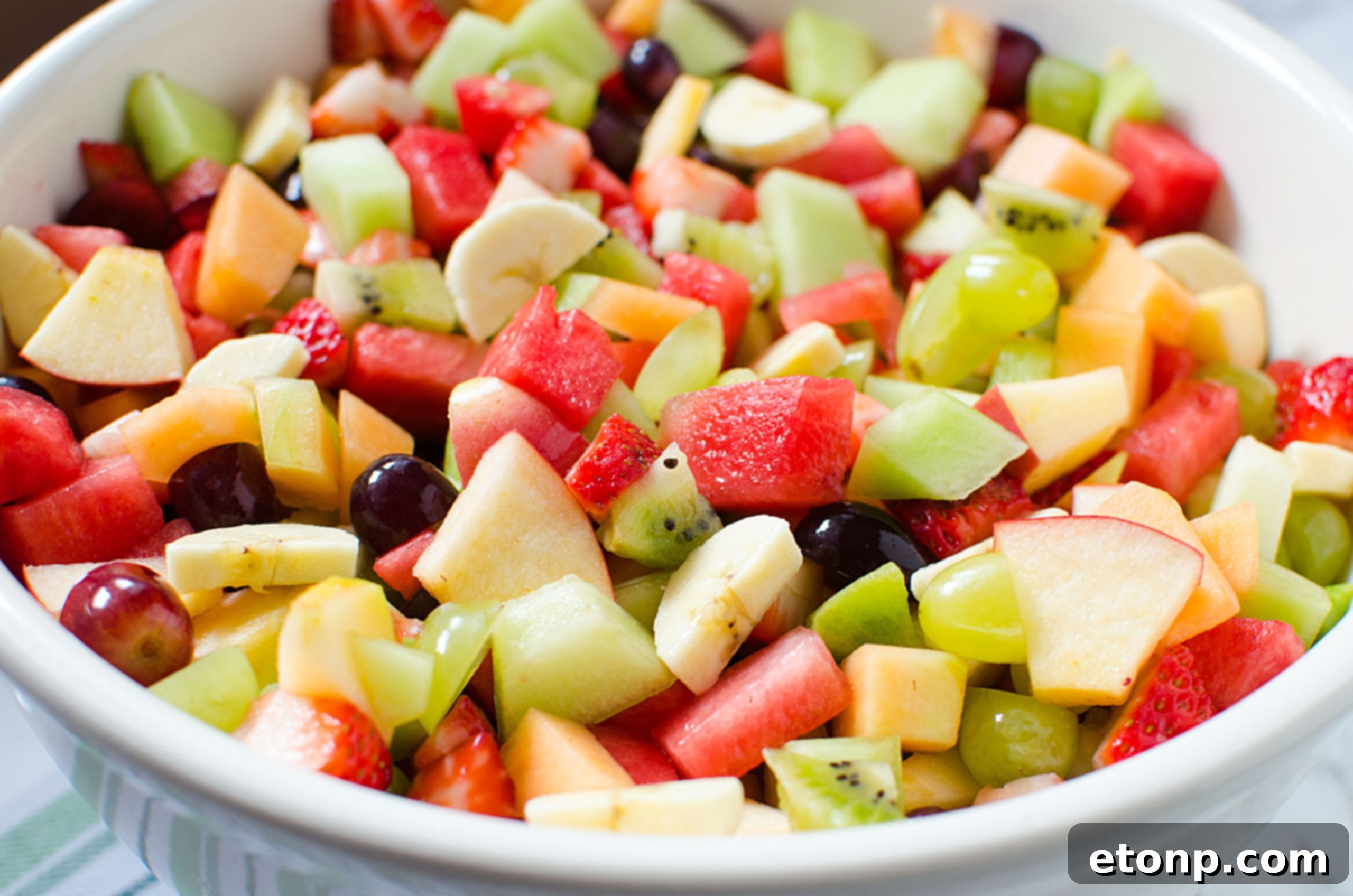 Close-up on a spoonful of mixed fresh fruit, highlighting the colors and textures