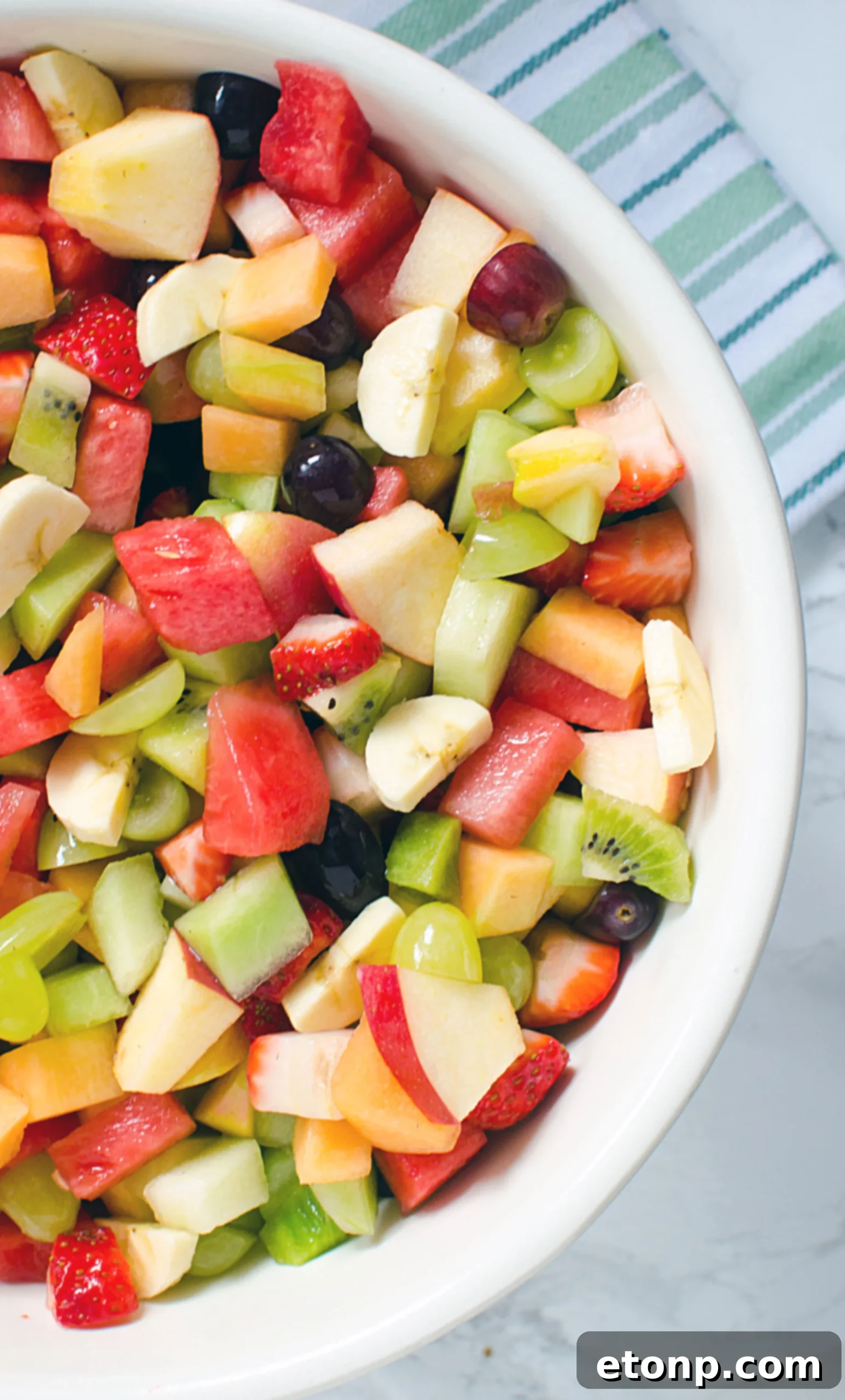 A refreshing bowl of fruit salad with ice, showcasing its ideal serving temperature
