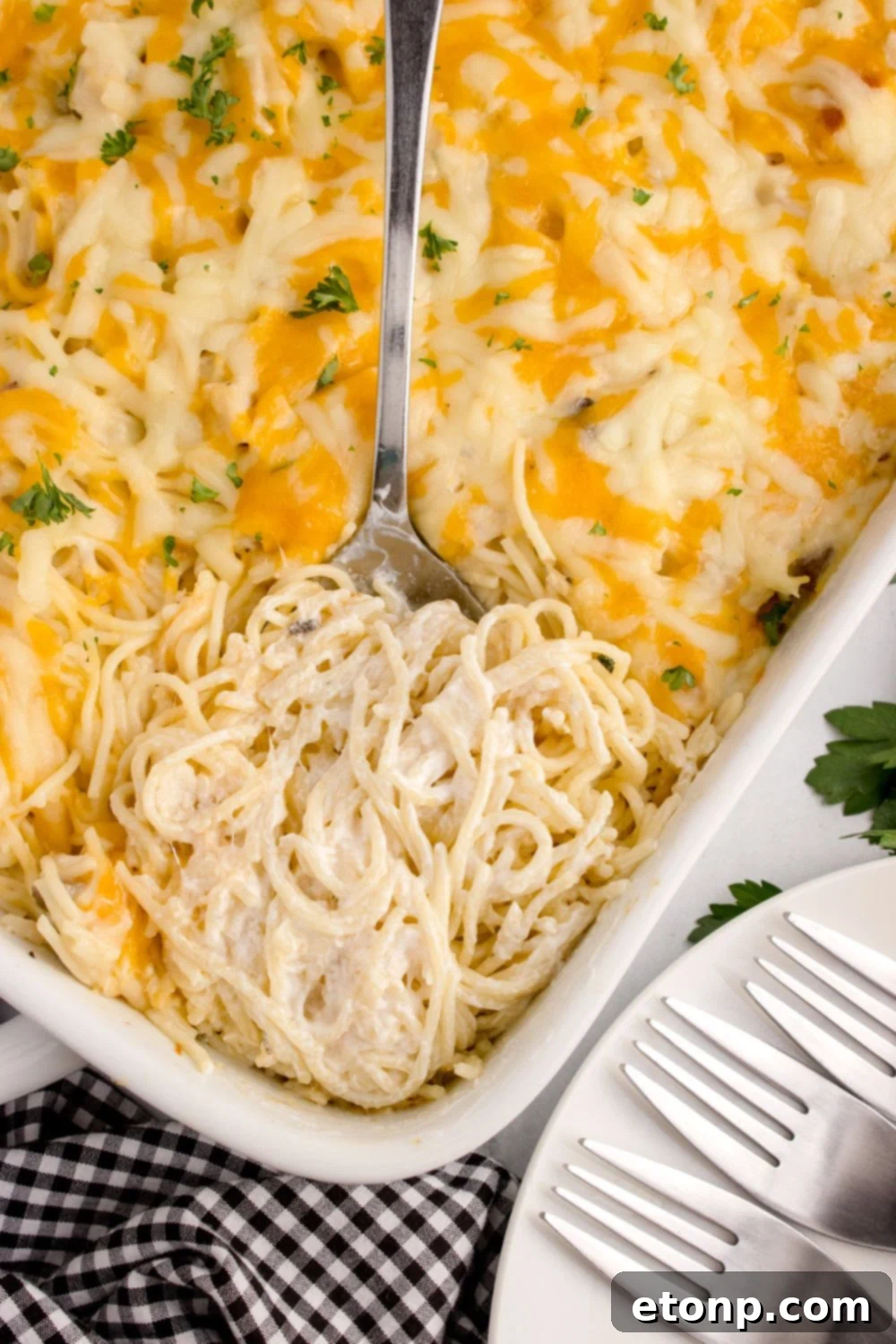 overhead look of chicken tetrazini in a pan with a spoon scooping some up