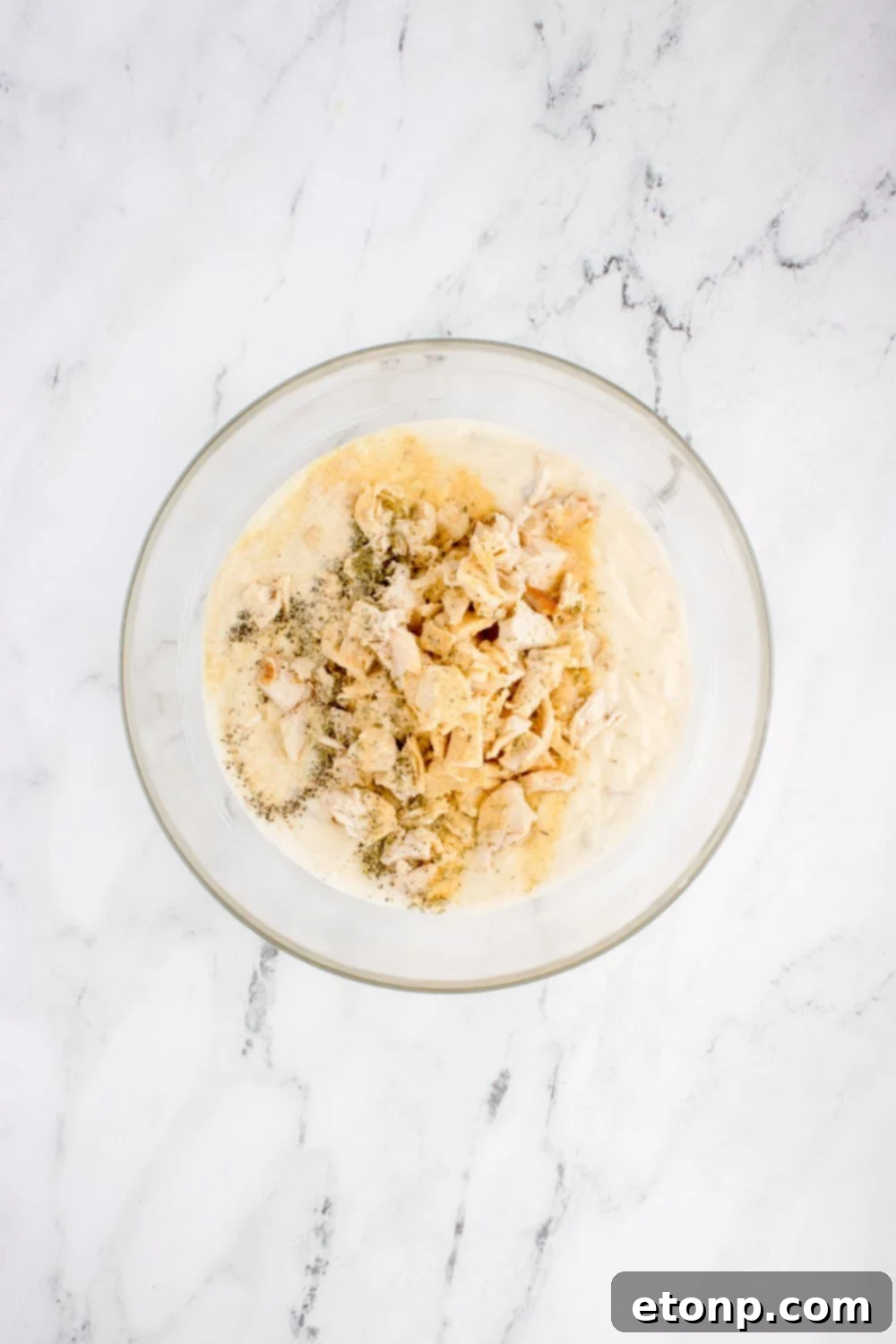 chicken and other ingredients in glass bowl for chicken tetrazzini on table 